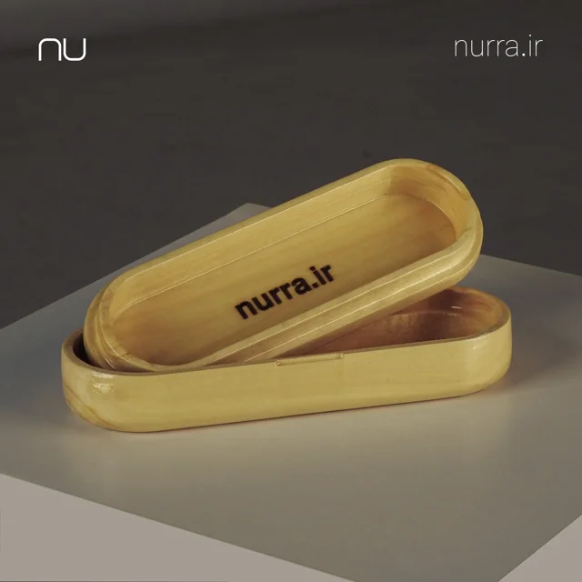 نمای داخلی جامدادی چوبی پیله و امضای حک‌شده nurra.ir روی در